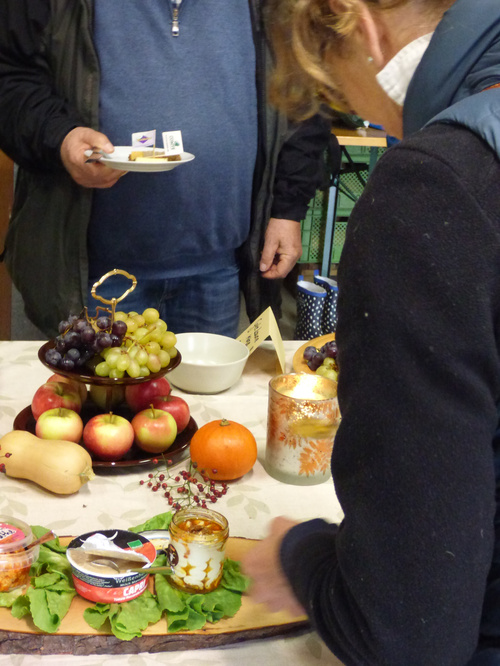 KI-generierte Beschreibung: Obst- und Gemüsestand mit Kundin.