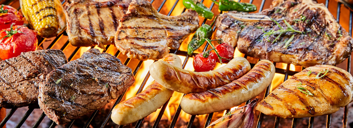 KI generiert: Verschiedene Fleischsorten und Gemüse auf einem Grill über offenem Feuer.