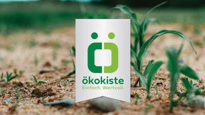 KI generiert: Eine Nahaufnahme von Pflanzen im Boden mit dem Text: "ökokiste Einfach. Wertvoll."