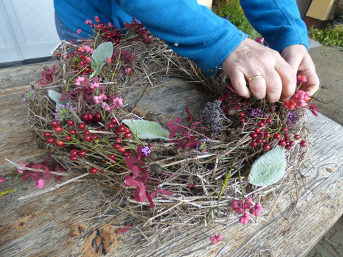 KI-generierte Beschreibung: Eine Person bindet einen Strauß Blumen. Hauptinhalt: Blumenbinden.