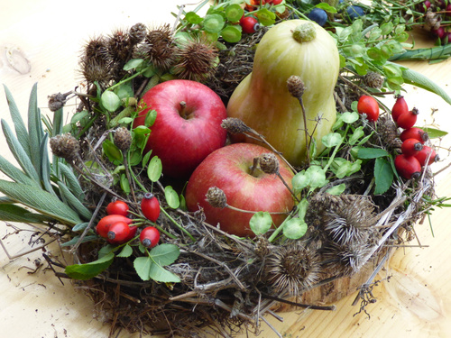 KI-generierte Beschreibung: Hauptinhalt: Verschiedene Äpfel und Tomaten auf einem Holzbrett.