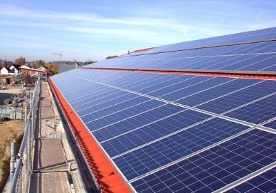 KI generiert: Solaranlage auf einem Dach, blaues Himmel im Hintergrund, Fokus auf die Solarpaneele.