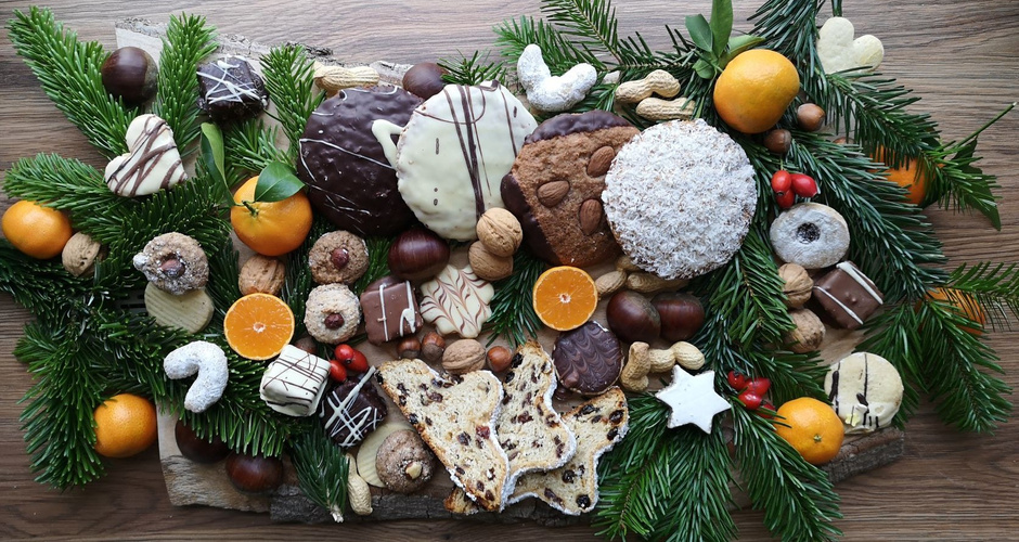 KI generiert: Weihnachtliche Kekse und Früchte auf einem Brett mit Tannenzweigen als Dekoration.