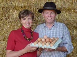 KI generiert: Ein Mann und eine Frau halten ein Tablett mit Eiern vor einem Heuballen.