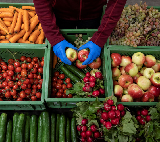 KI-generierte Beschreibung: Hauptinhalt: Frisches Obst und Gemüse in Holzkisten.