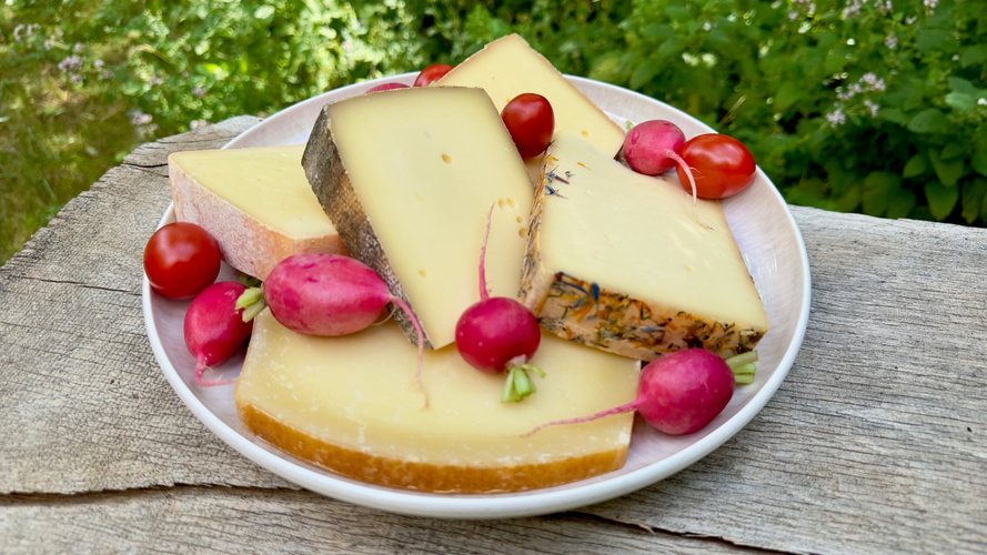 KI generiert: Ein Teller mit verschiedenen Käsesorten und Radieschen.