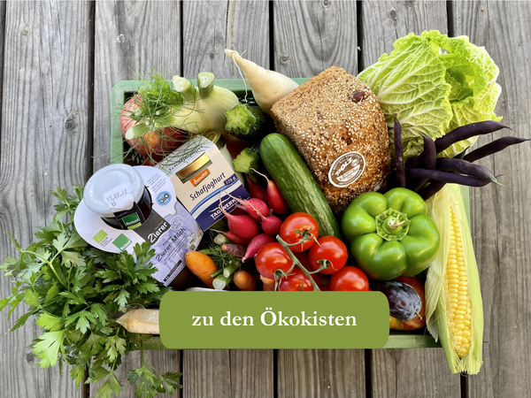KI generiert: Eine Vielfalt an frischem Gemüse und Brot in einem Korb. Text: "zu den Ökokisten".