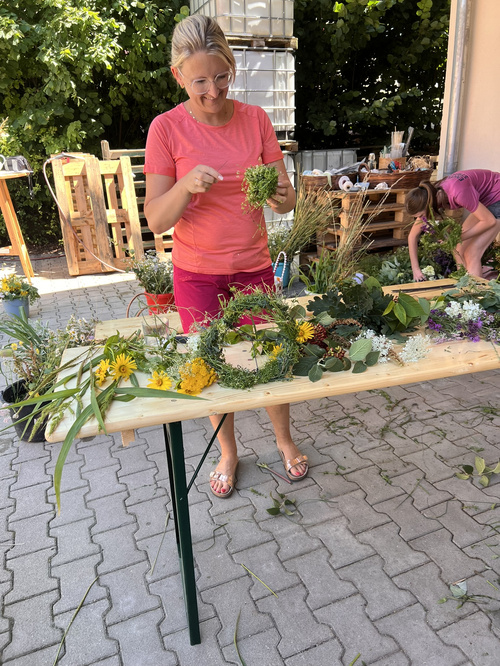 KI-generierte Beschreibung: Eine Frau hält einen Blumenstrauß in einem Garten.
