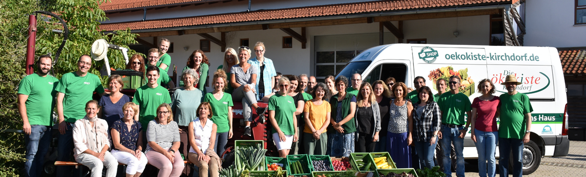 KI generiert: Eine Gruppe posiert vor einem Lieferwagen. Text: "oekokiste-kirchdorf.de".