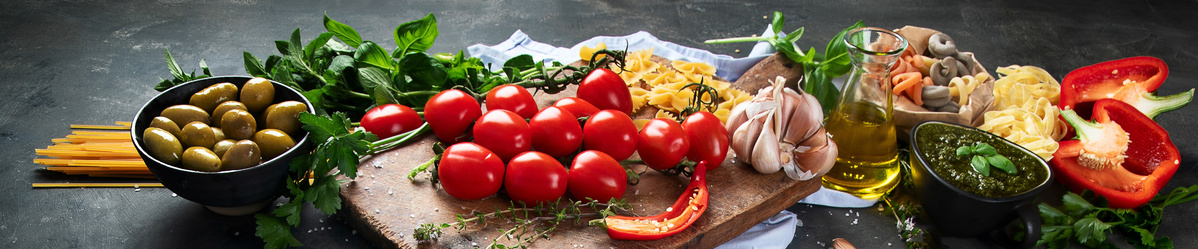 KI generiert: Eine Vielzahl frischer Zutaten wie Tomaten, Knoblauch, Oliven, Pasta und Kräuter auf einem Tisch.