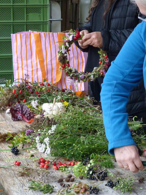 KI-generierte Beschreibung: Person pflanzt Blumen in Hochbeet.