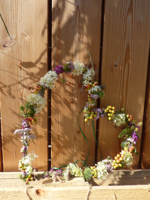 KI-generierte Beschreibung: Holzlatten mit Blumensträußen als Hauptinhalt.