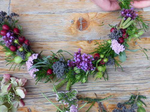 KI-generierte Beschreibung: Blumenstrauß in einer Holzschale auf Holzboden.