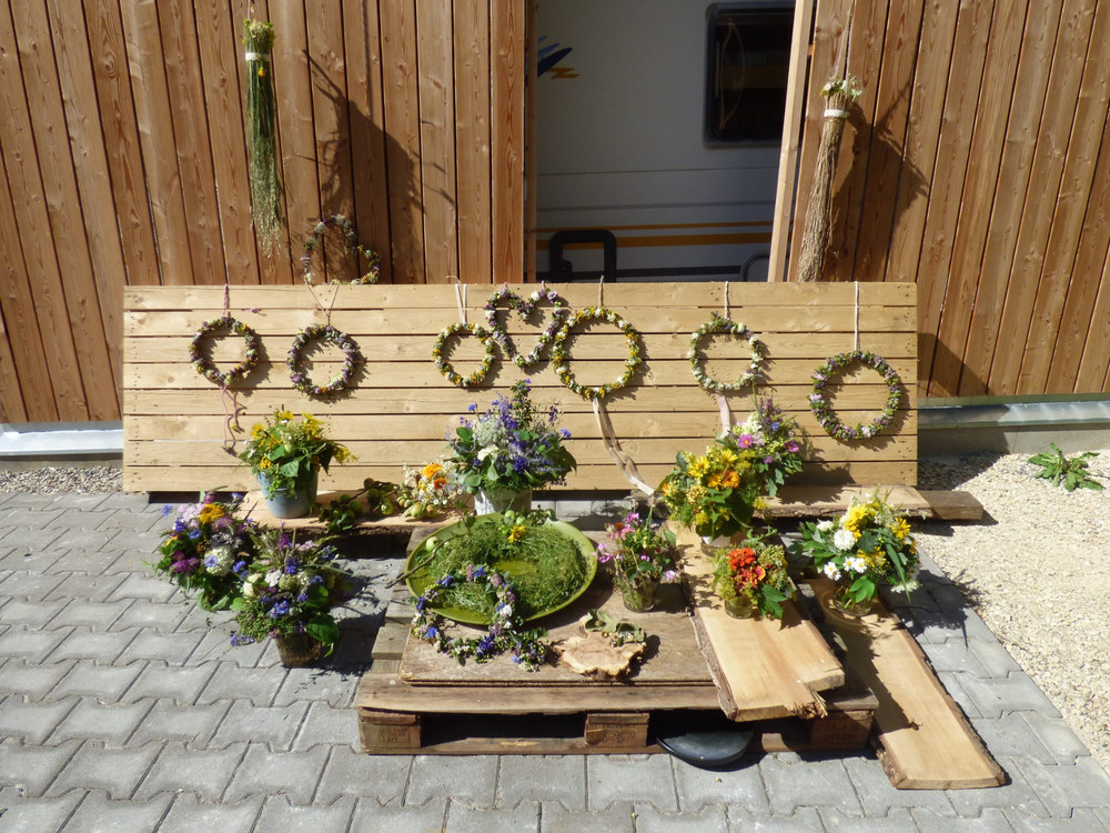 KI-generierte Beschreibung: Holzhaus mit Blumenkübeln vor der Tür.