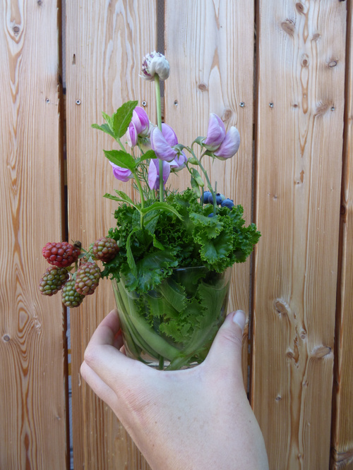 KI-generierte Beschreibung: Blumenstrauß in einer Vase auf einem Holztisch.